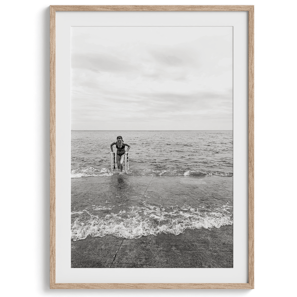 A black and white fine art lake beach print of a beach in Chicago on the coast of Lake Michigan showcasing a woman bathing in the lake. The classic modern look of the print is sure to impress when hung on your walls.