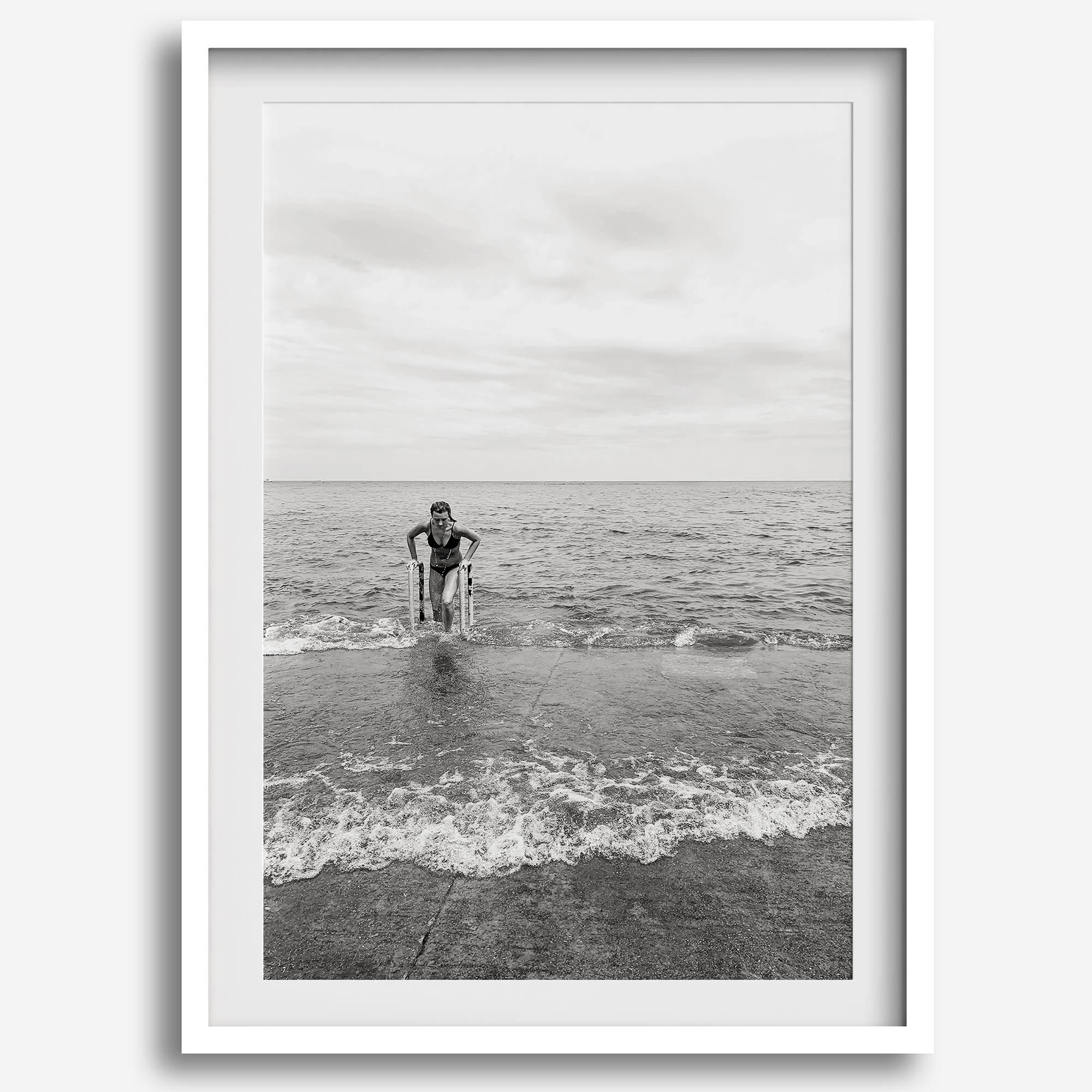 A black and white fine art lake beach print of a beach in Chicago on the coast of Lake Michigan showcasing a woman bathing in the lake. The classic modern look of the print is sure to impress when hung on your walls.