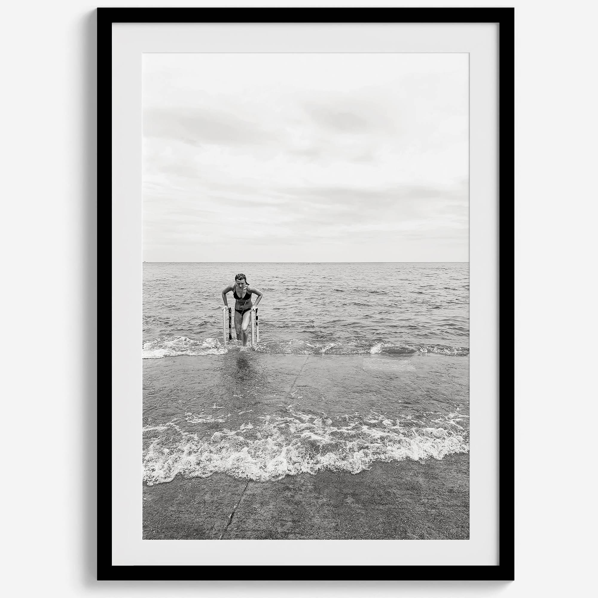 A black and white fine art lake beach print of a beach in Chicago on the coast of Lake Michigan showcasing a woman bathing in the lake. The classic modern look of the print is sure to impress when hung on your walls.