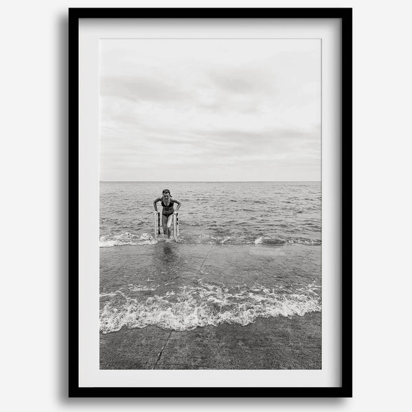 A black and white fine art lake beach print of a beach in Chicago on the coast of Lake Michigan showcasing a woman bathing in the lake. The classic modern look of the print is sure to impress when hung on your walls.