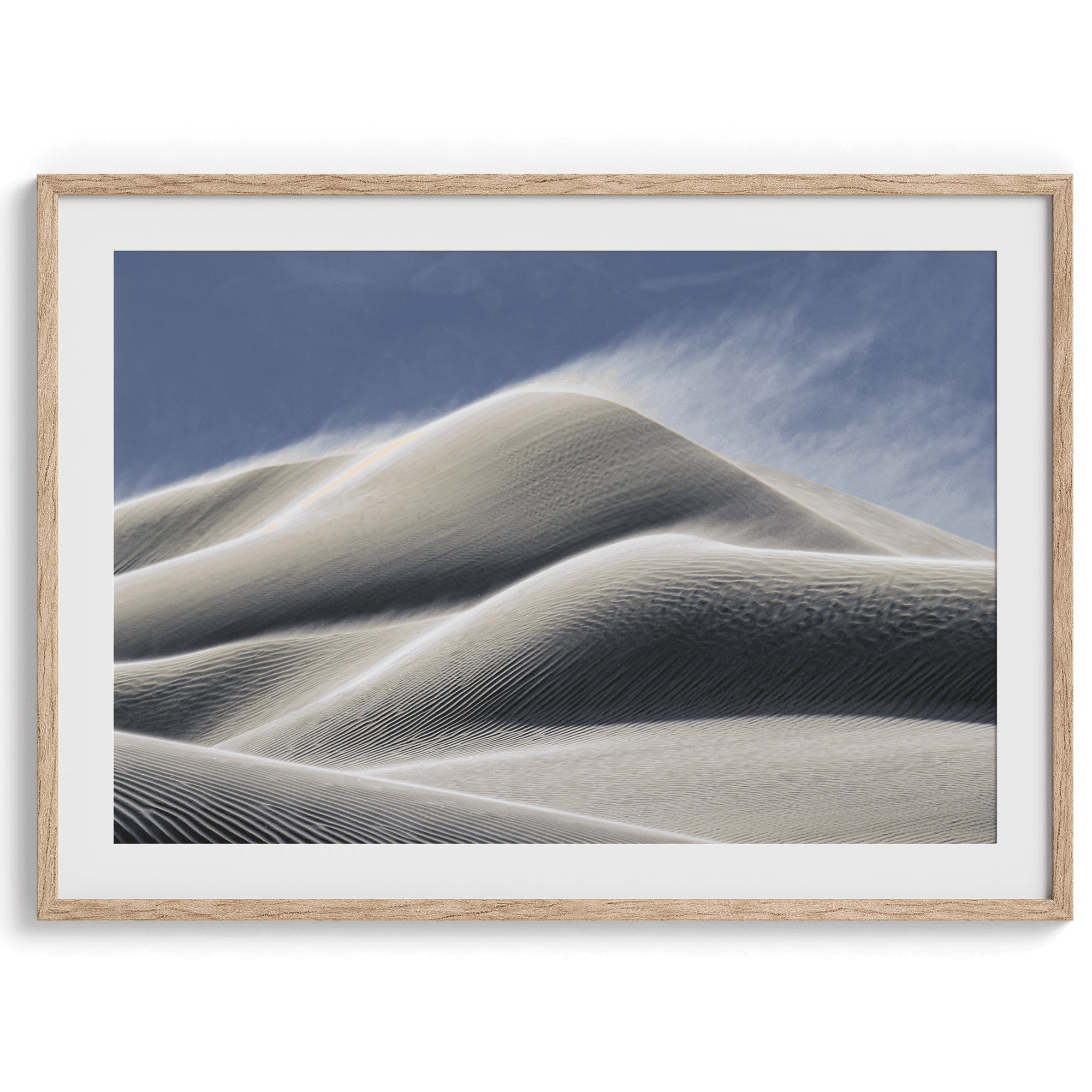 Fine art photo of Mesquite Flat Sand Dunes in Death Valley at golden hour. Windblown sand creates textured patterns across the immense dunes, bathed in warm light.