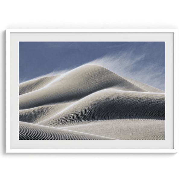 Fine art photo of Mesquite Flat Sand Dunes in Death Valley at golden hour. Windblown sand creates textured patterns across the immense dunes, bathed in warm light.
