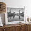Black and white fine art photo of a serene mountain and forest mirrored in a still lake at sunset.
