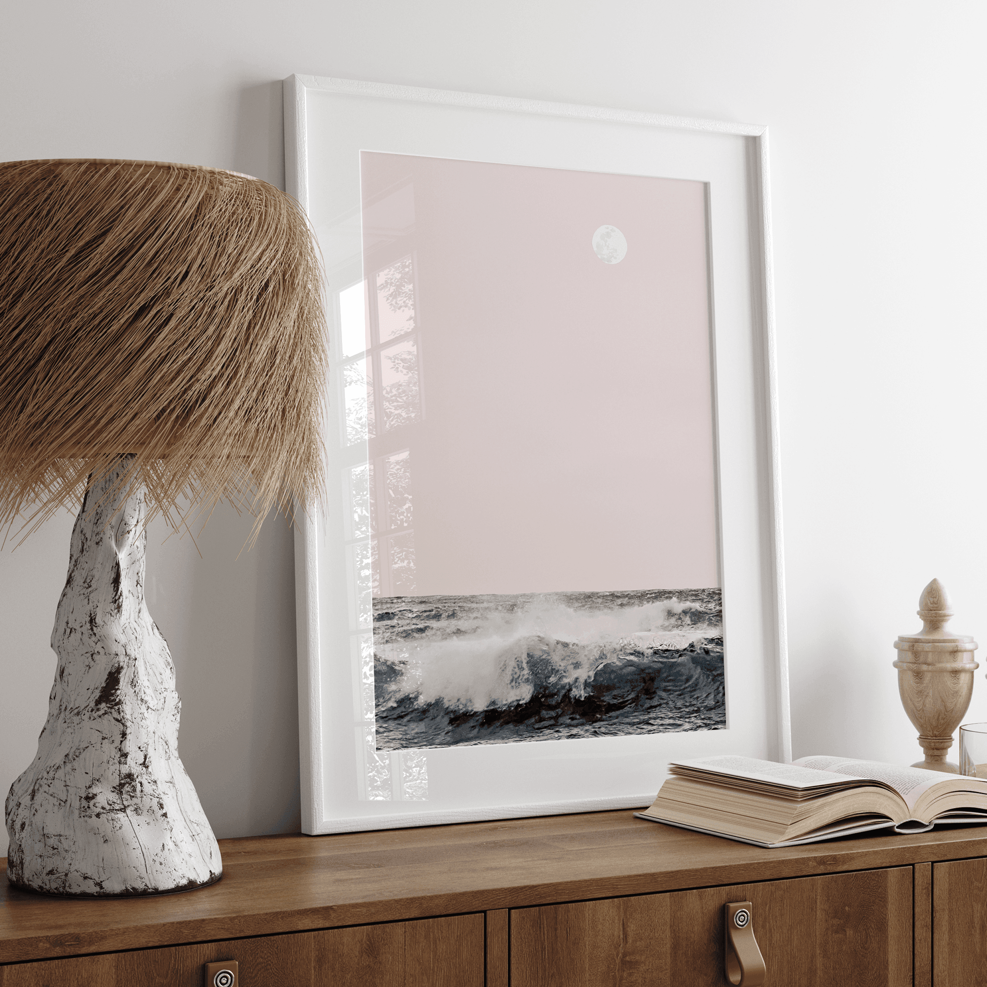 This extraordinary ocean wall art captures a mesmerizing moment when a powerful wave crashes while the sunset gentle blush pink hues fill the sky and a large full moon rises majestically in the backdrop.