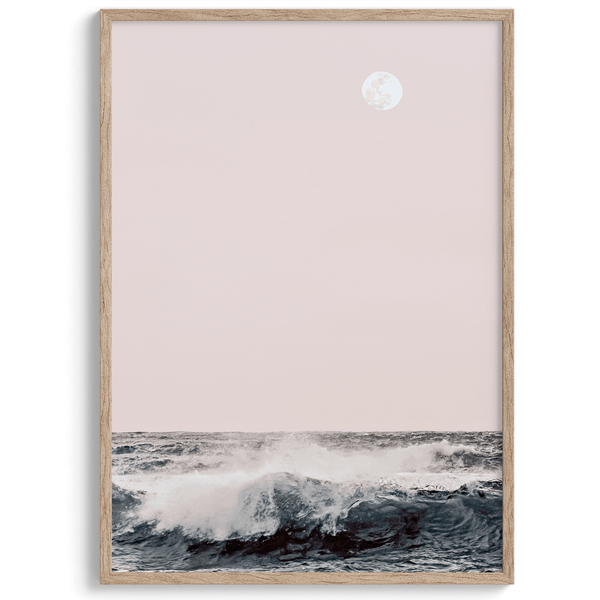 This extraordinary ocean wall art captures a mesmerizing moment when a powerful wave crashes while the sunset gentle blush pink hues fill the sky and a large full moon rises majestically in the backdrop.