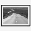 Black and white fine art photo of a winding desert road stretching through a vast minimalist landscape.