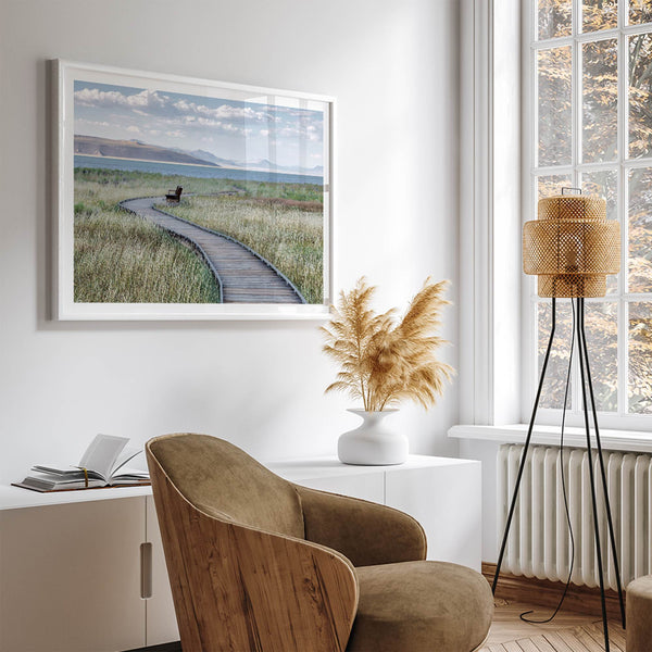 Framed Mono Lake nature photography print featuring a winding boardwalk through tall grasses, leading to a quiet bench beside the lake with mountains in the background.