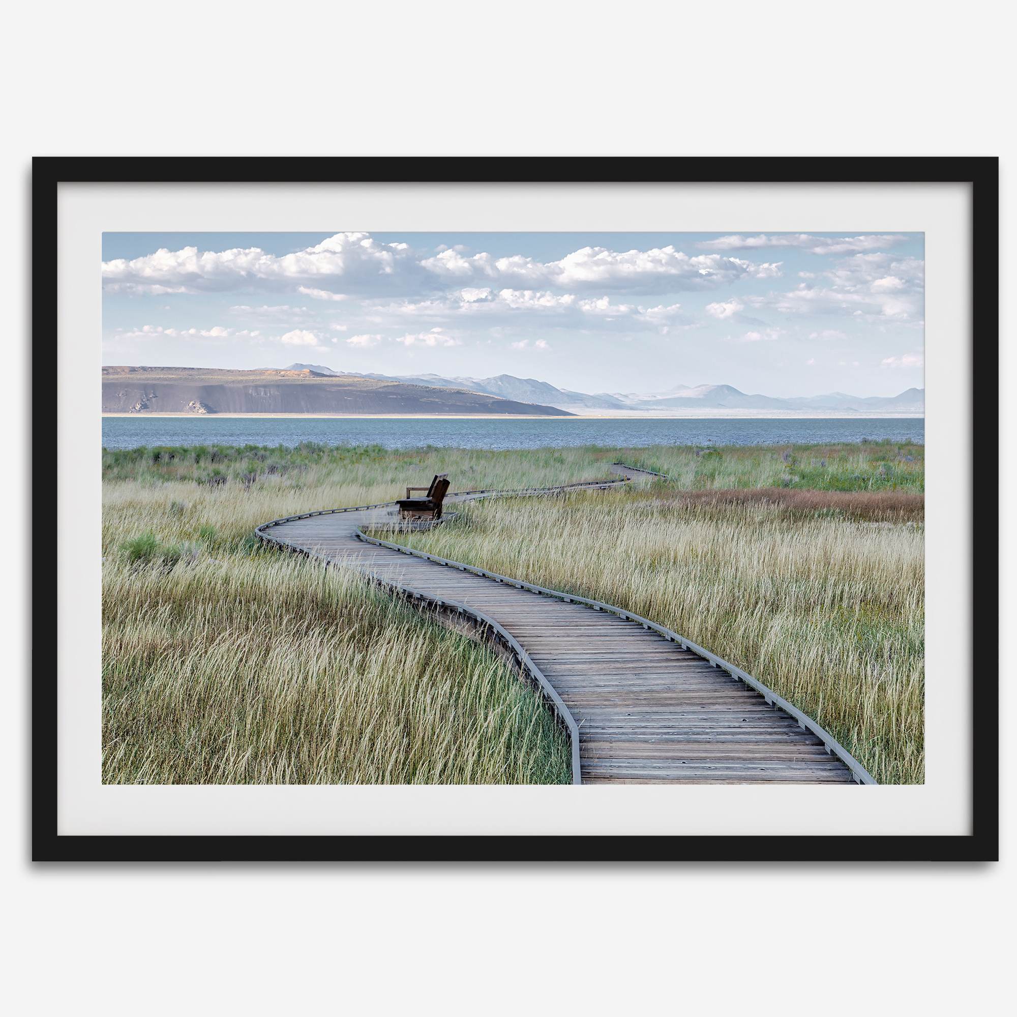 Framed Mono Lake nature photography print featuring a winding boardwalk through tall grasses, leading to a quiet bench beside the lake with mountains in the background.