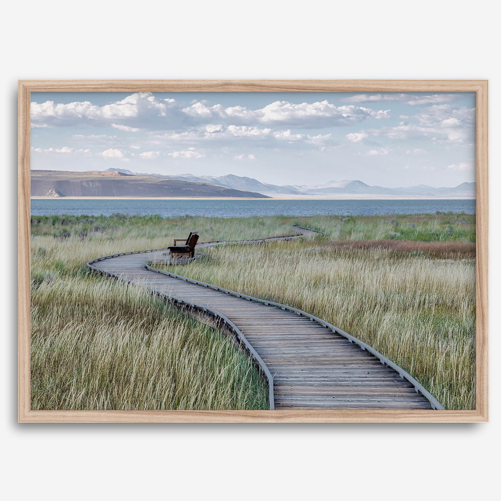 Framed Mono Lake nature photography print featuring a winding boardwalk through tall grasses, leading to a quiet bench beside the lake with mountains in the background.