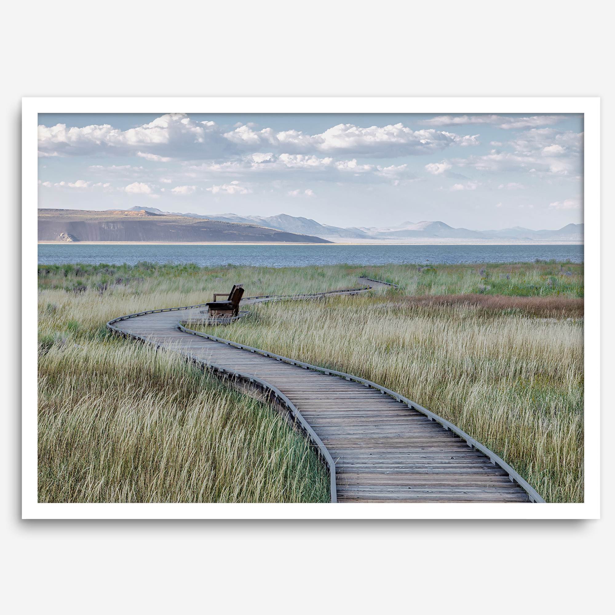 Framed Mono Lake nature photography print featuring a winding boardwalk through tall grasses, leading to a quiet bench beside the lake with mountains in the background.