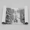 A fine art black and white mountain ski print showing a ski lift winding up the mountain with a stunning winter snow forest around it.