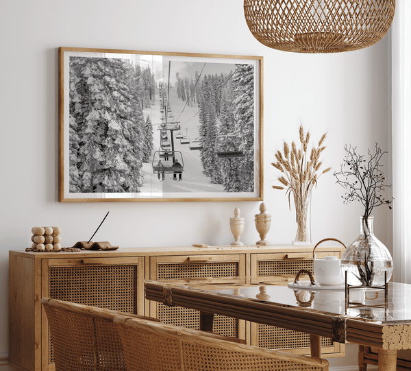 A fine art black and white mountain ski print showing a ski lift winding up the mountain with a stunning winter snow forest around it.