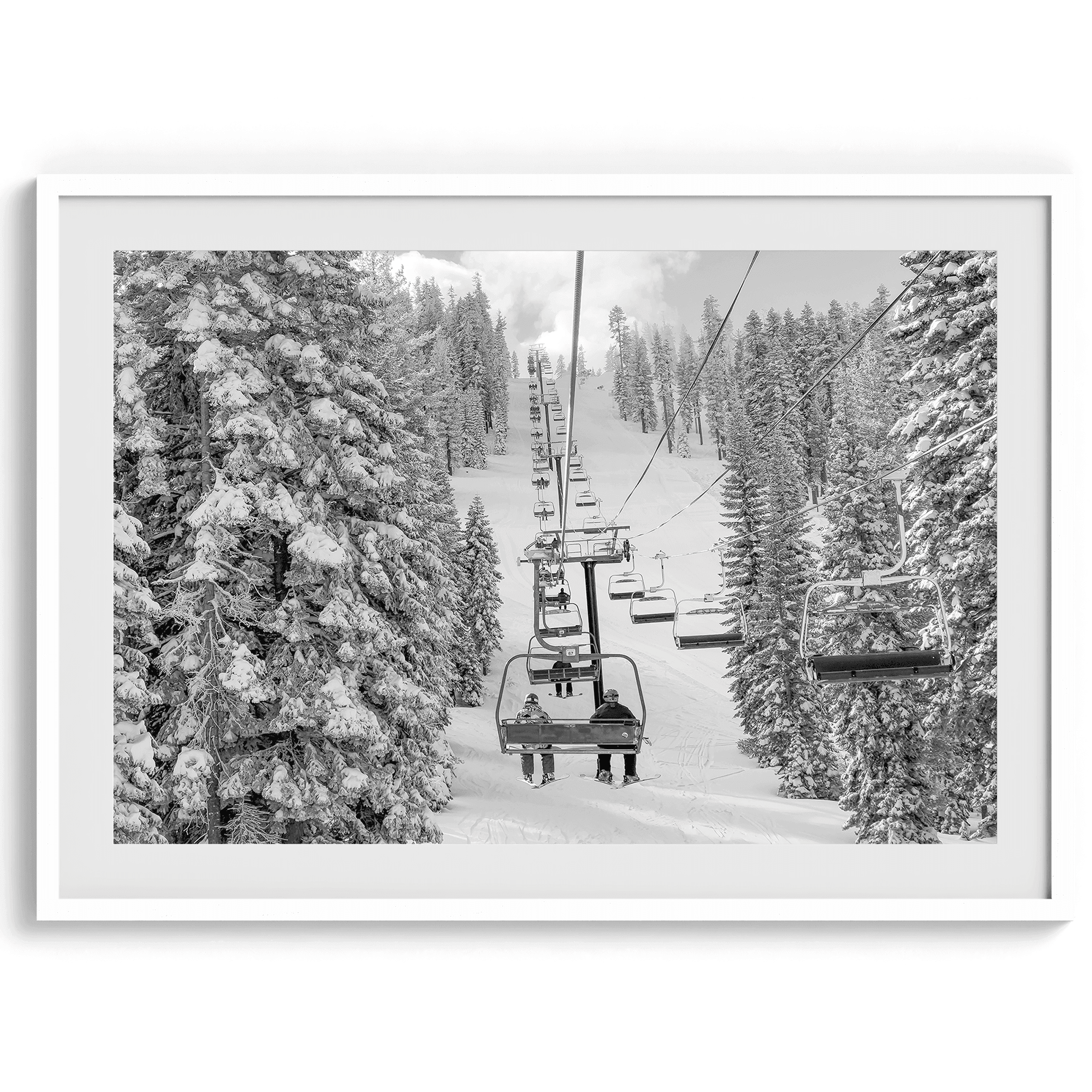 A fine art black and white mountain ski print showing a ski lift winding up the mountain with a stunning winter snow forest around it.