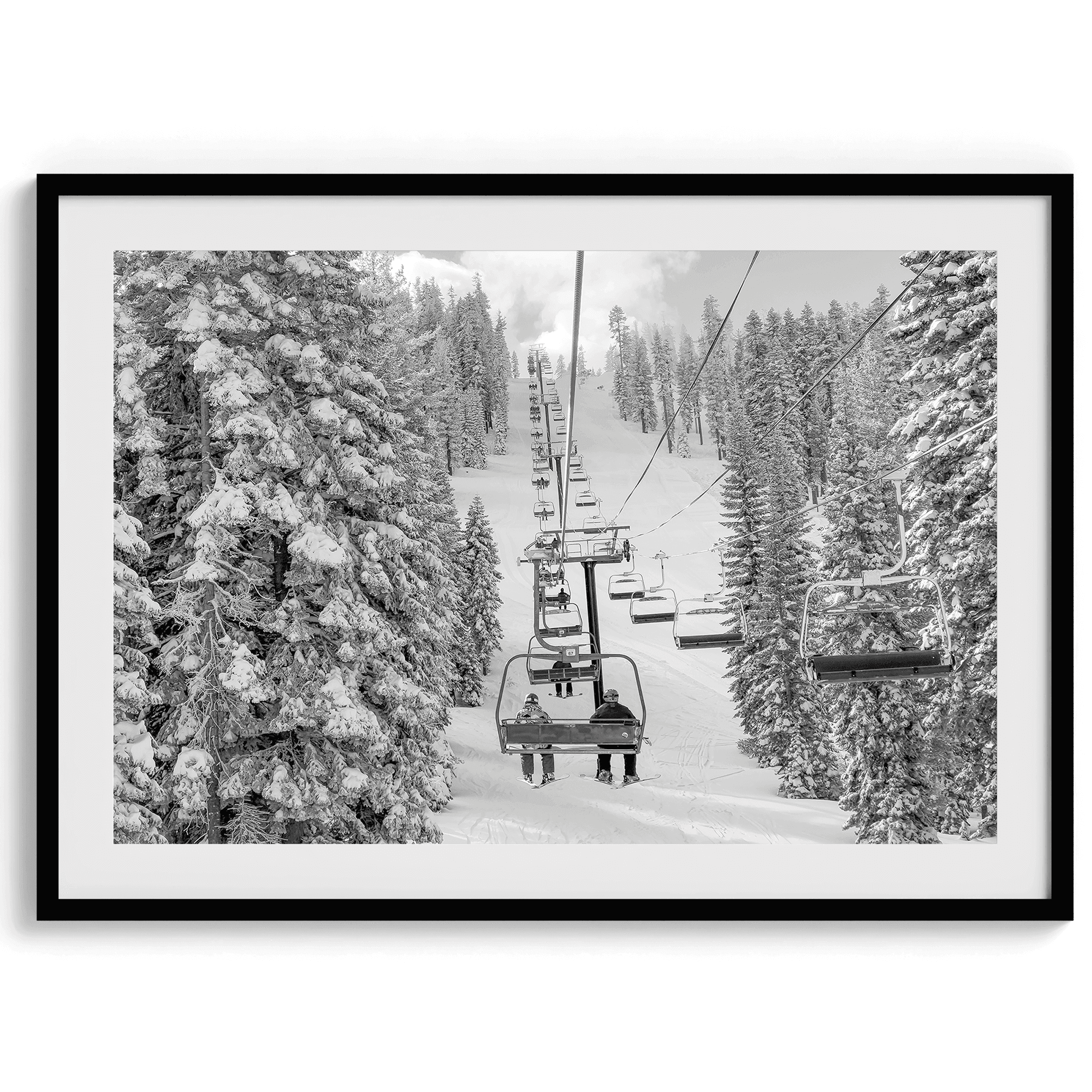 A fine art black and white mountain ski print showing a ski lift winding up the mountain with a stunning winter snow forest around it.