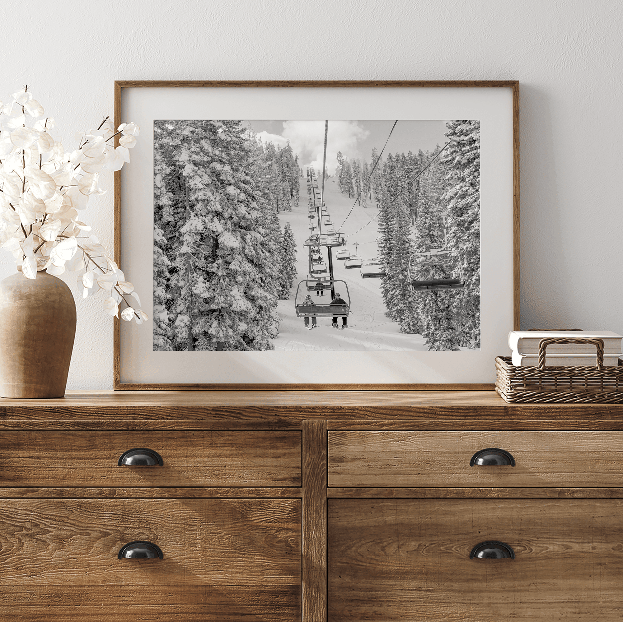 A fine art black and white mountain ski print showing a ski lift winding up the mountain with a stunning winter snow forest around it.