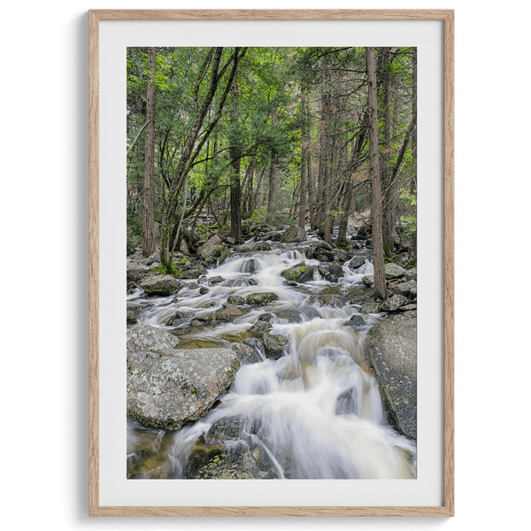 A beautiful river cuts through the forest, shot in long exposure making the water look creamy and calm in this fine art Yosemite National Park print.