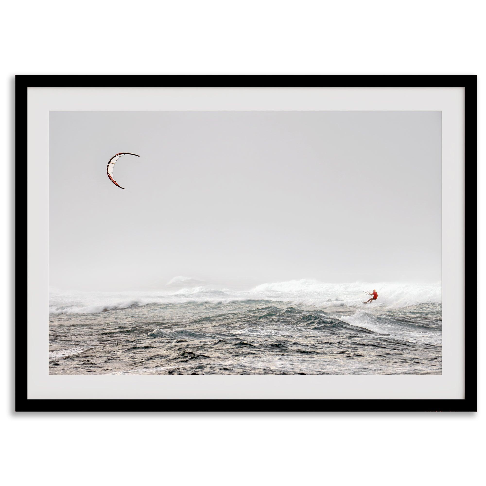 Wind surfer riding waves in Maui with kite above and misty ocean below.