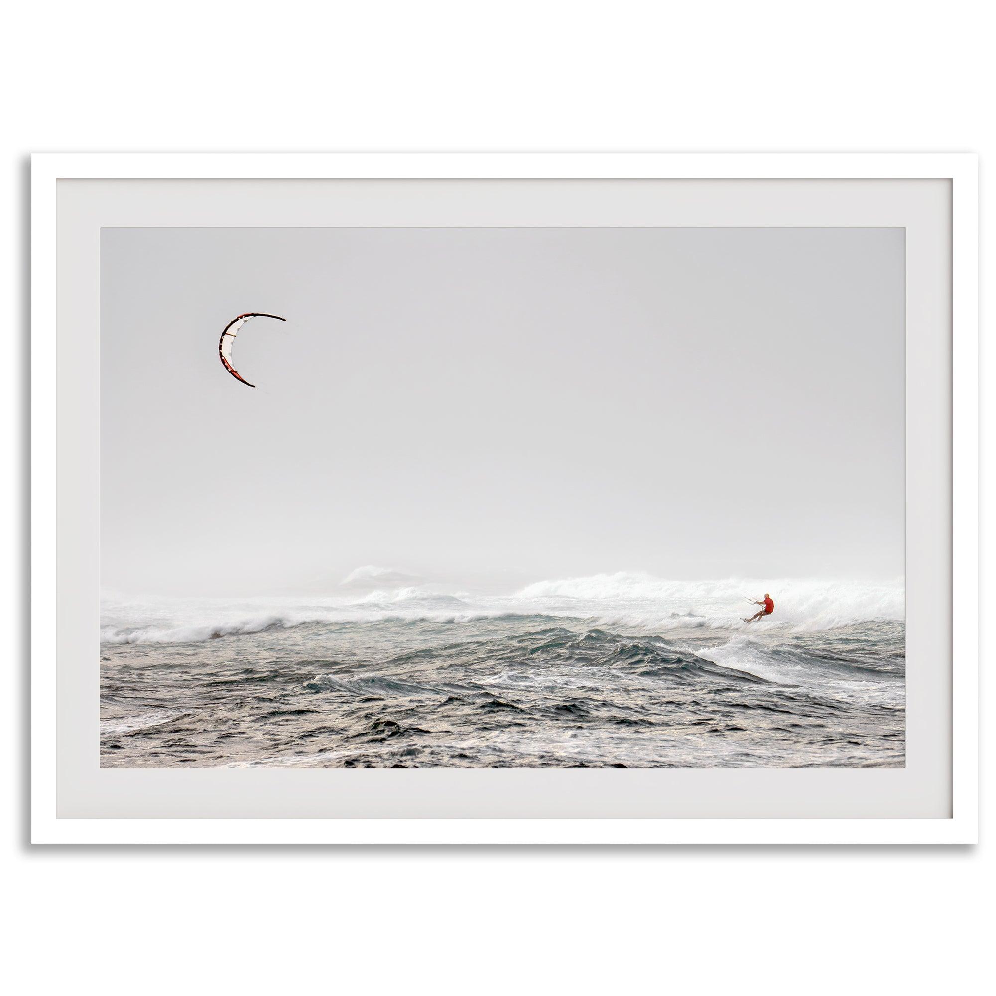 Wind surfer riding waves in Maui with kite above and misty ocean below.