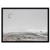 Wind surfer riding waves in Maui with kite above and misty ocean below.