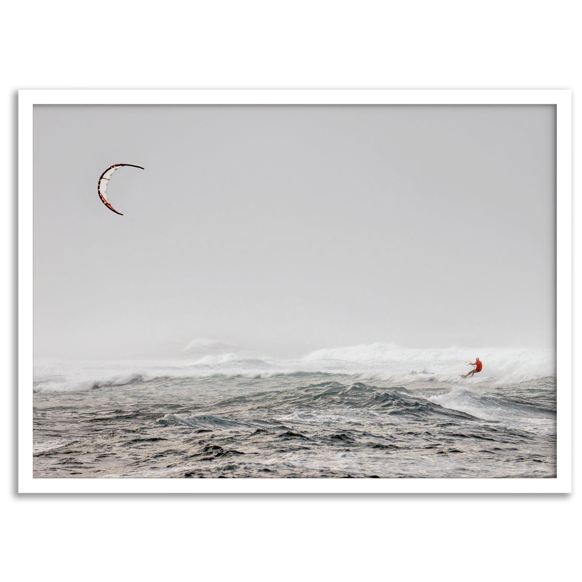 Wind surfer riding waves in Maui with kite above and misty ocean below.