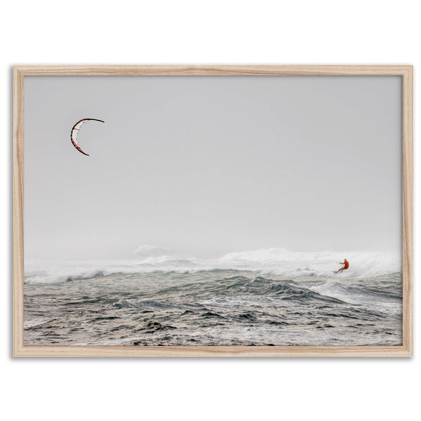 Wind surfer riding waves in Maui with kite above and misty ocean below.