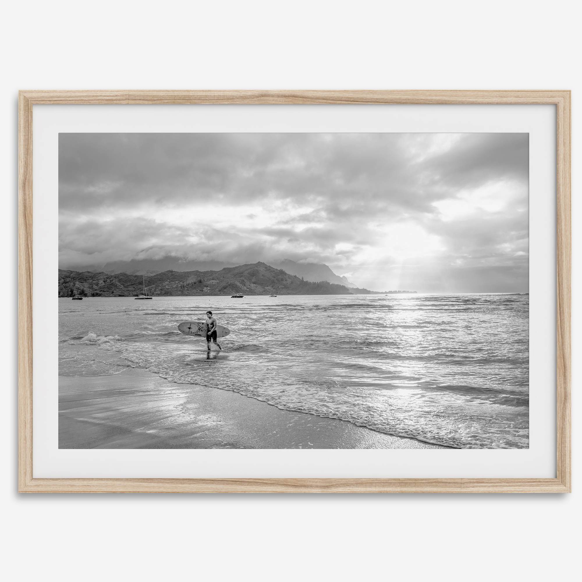 Surfer Wall Art featuring a lone surfer emerging from the ocean at Hanalei Bay in black-and-white photography.