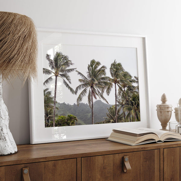 Tropical beach palm tree art with lush green palms against a misty hillside in coastal landscape