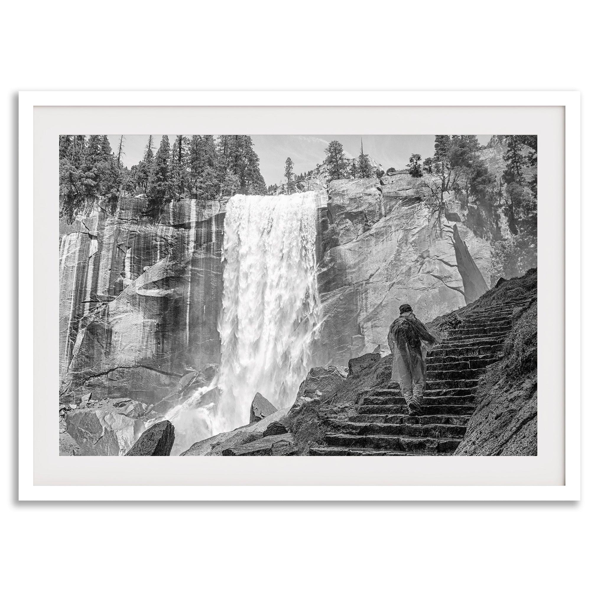 Climb the breathtaking Mist Trail in Yosemite National Part with this fine art black and white waterfall nature print. This nature landscape wall art showcases the stunning gushing waterfall and the people scaling the trail with their colorful raincoats.