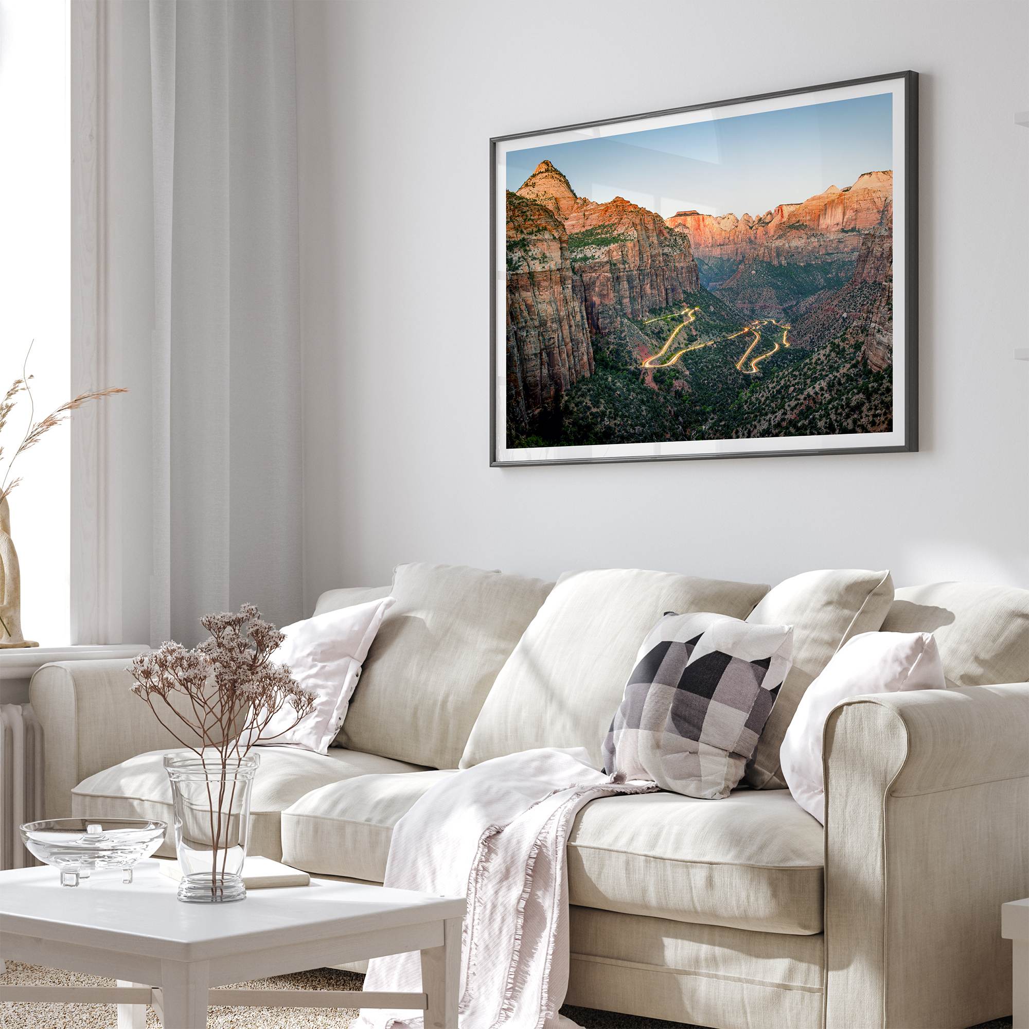 Framed Zion National Park print with winding road illuminated through red cliffs and majestic canyon scenery at dusk.