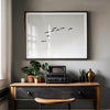 birds in flight wall art with airplane, framed black and white minimalist photography print on white wall.