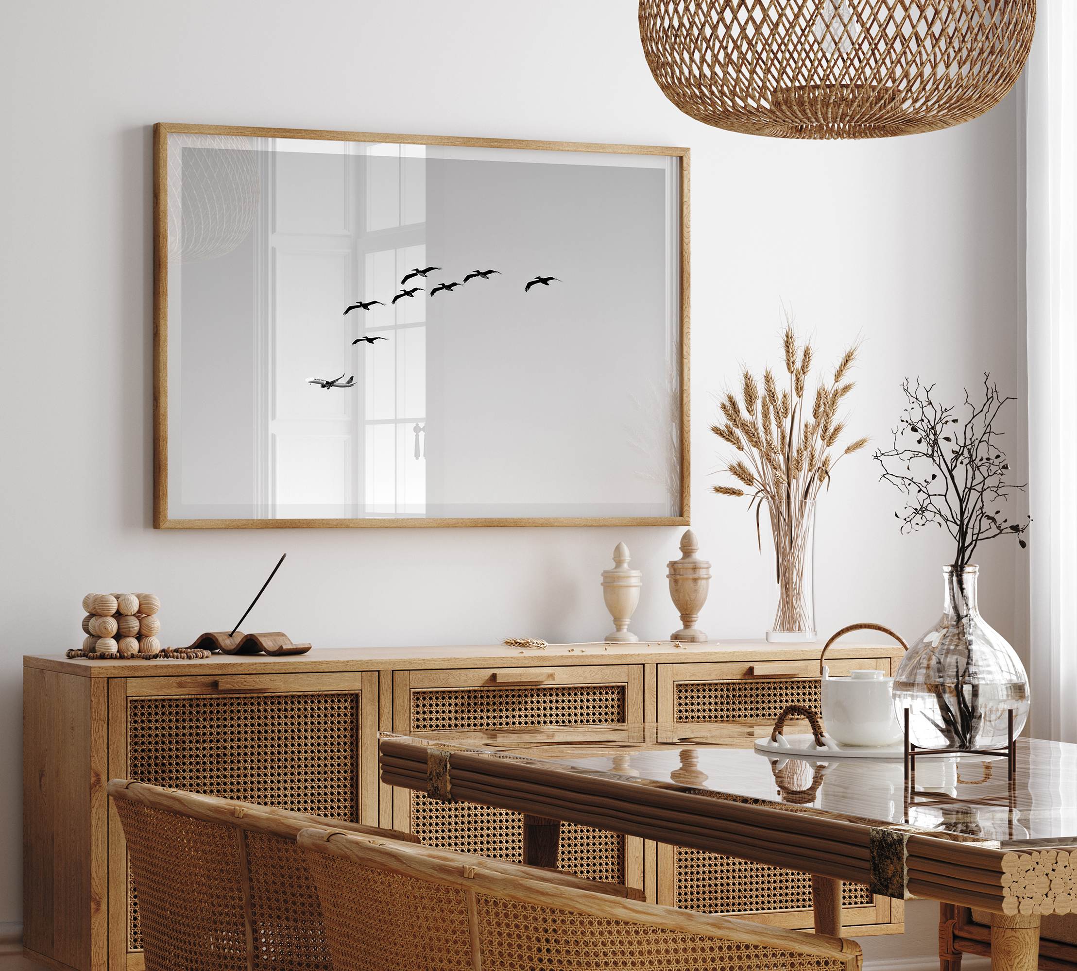 birds in flight wall art with airplane, framed black and white minimalist photography print on white wall.