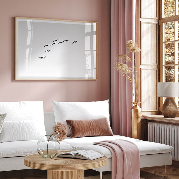 birds in flight wall art with airplane, framed black and white minimalist photography print on white wall.