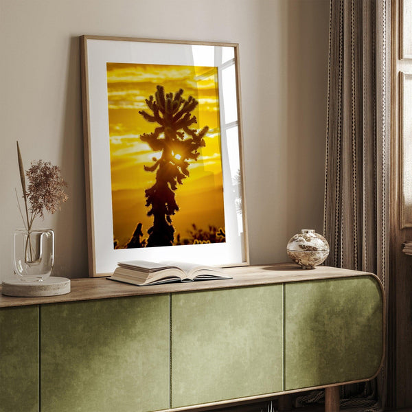 Silhouetted cactus against a vibrant yellow sunset in Joshua Tree National Park, capturing desert beauty.