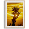 Silhouetted cactus against a vibrant yellow sunset in Joshua Tree National Park, capturing desert beauty.