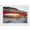 Canyonlands wall art featuring Mesa Arch at sunrise, with sunlight shining through the snow-covered arch over a vast canyon landscape.