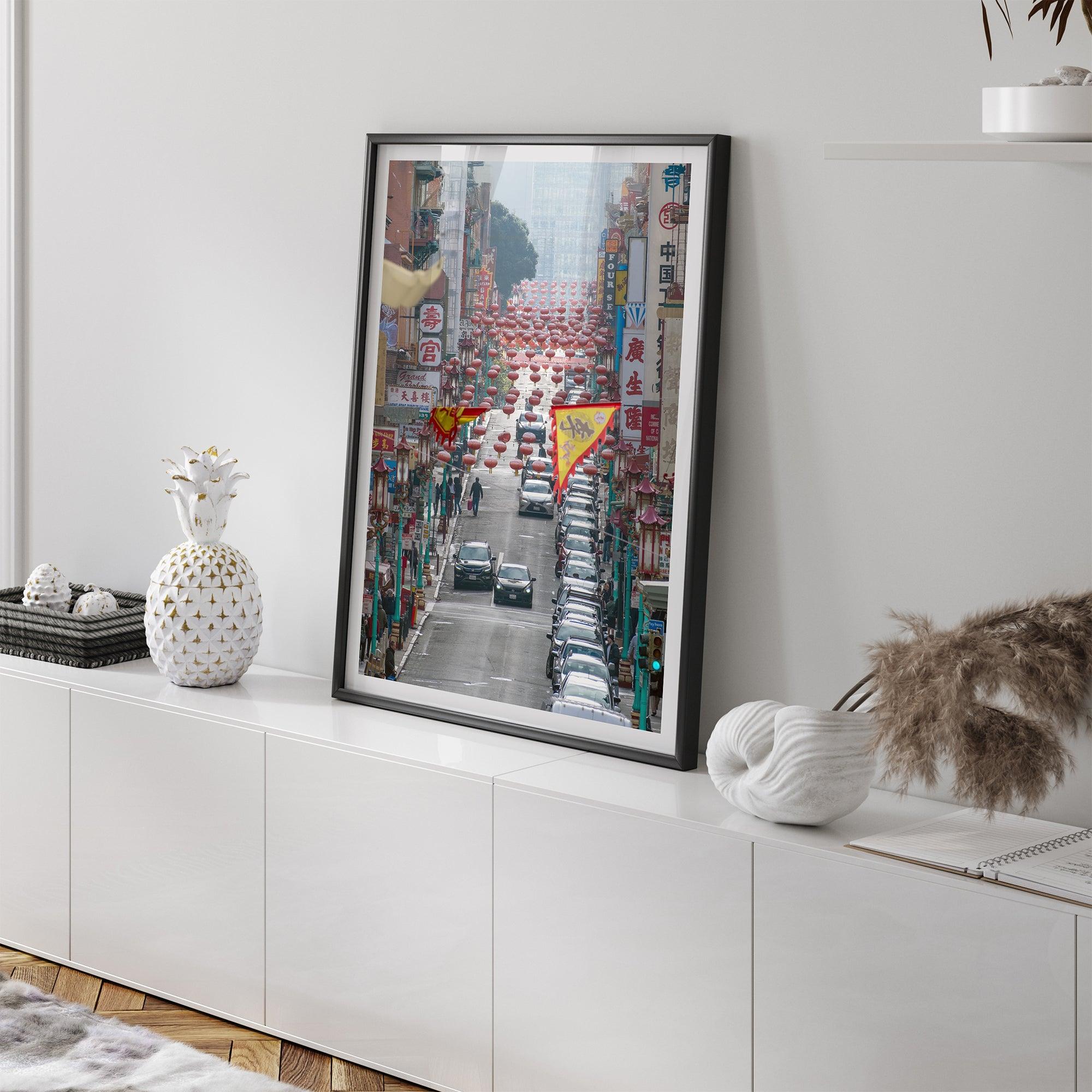 Red lanterns line Grant Avenue in San Francisco’s Chinatown, framed by colorful signs and bustling city life. Available as a framed or unframed print.