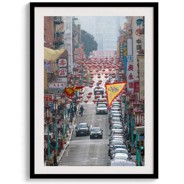 Red lanterns line Grant Avenue in San Francisco’s Chinatown, framed by colorful signs and bustling city life. Available as a framed or unframed print.