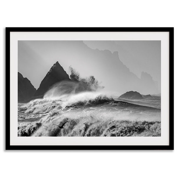 Black and white crashing waves wall art with dramatic ocean spray, jagged cliffs, and a moody atmosphere.