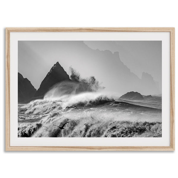 Black and white crashing waves wall art with dramatic ocean spray, jagged cliffs, and a moody atmosphere.