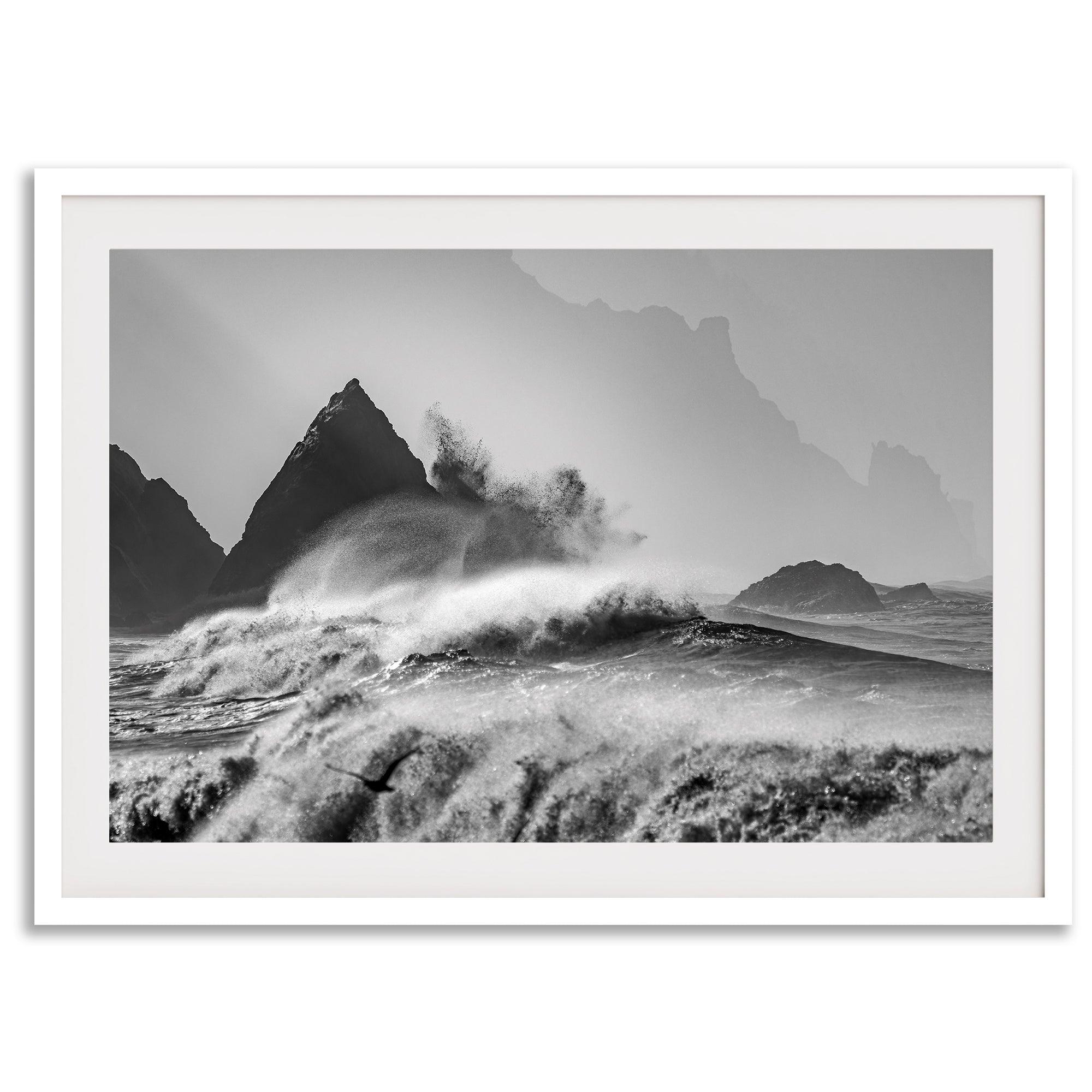 Black and white crashing waves wall art with dramatic ocean spray, jagged cliffs, and a moody atmosphere.