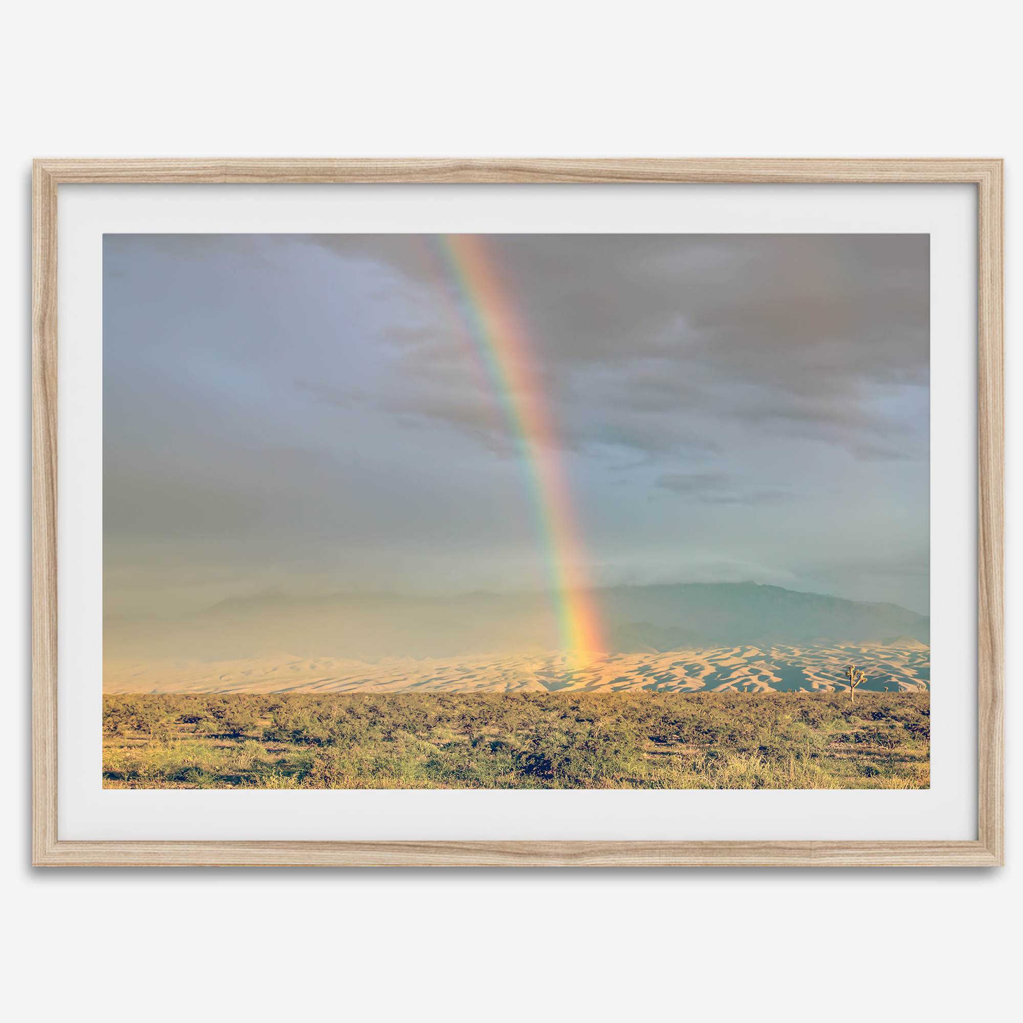 Desert landscape artwork of a rainbow over Arizona sand dunes with distant mountains.