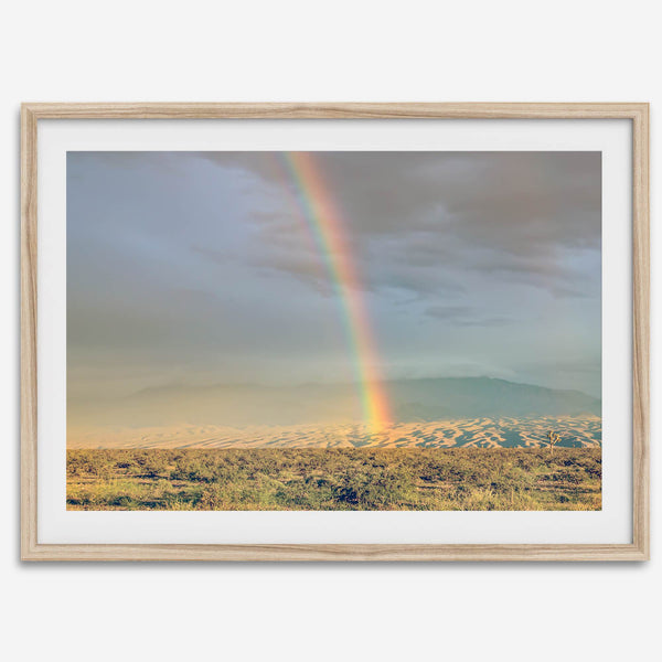 Desert landscape artwork of a rainbow over Arizona sand dunes with distant mountains.