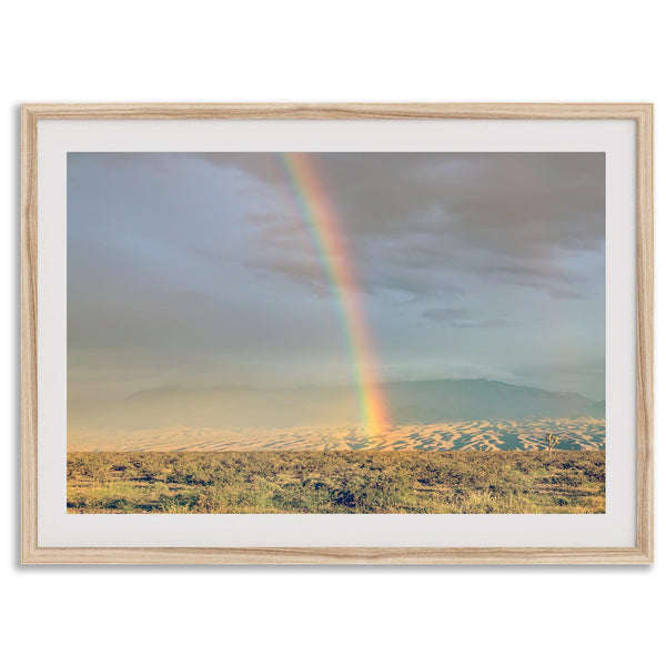 Desert landscape artwork of a rainbow over Arizona sand dunes with distant mountains
