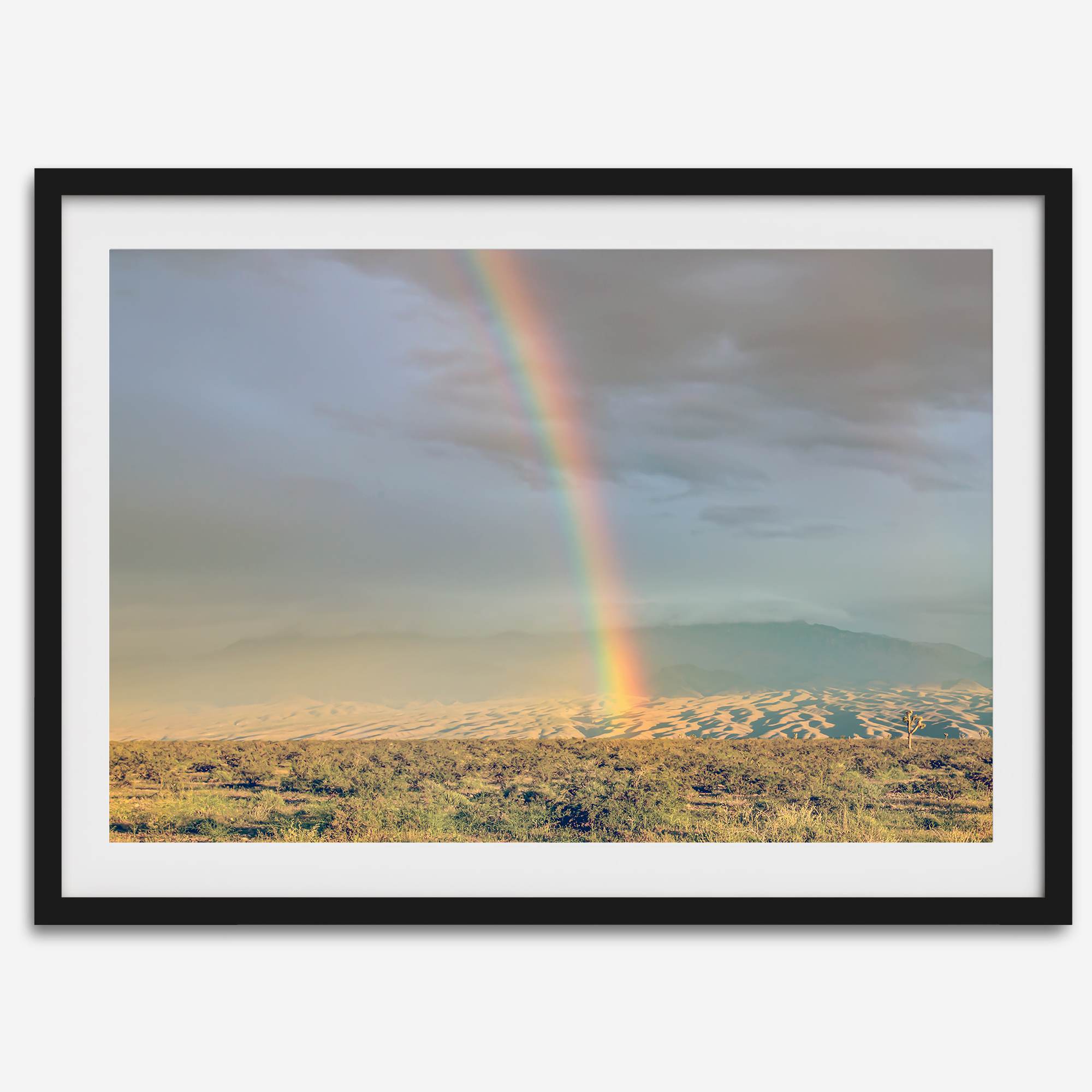 Desert landscape artwork of a rainbow over Arizona sand dunes with distant mountains.