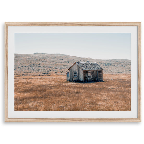 Rustic farmhouse in the Wild West surrounded by golden fields, capturing the essence of American frontier life.