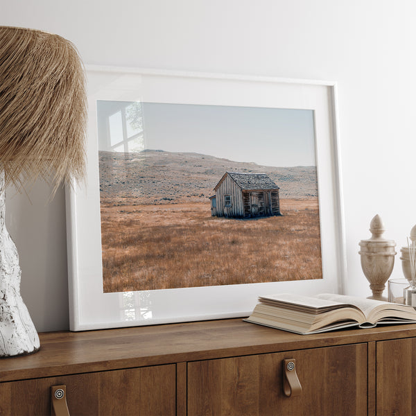 Rustic farmhouse in the Wild West surrounded by golden fields, capturing the essence of American frontier life.