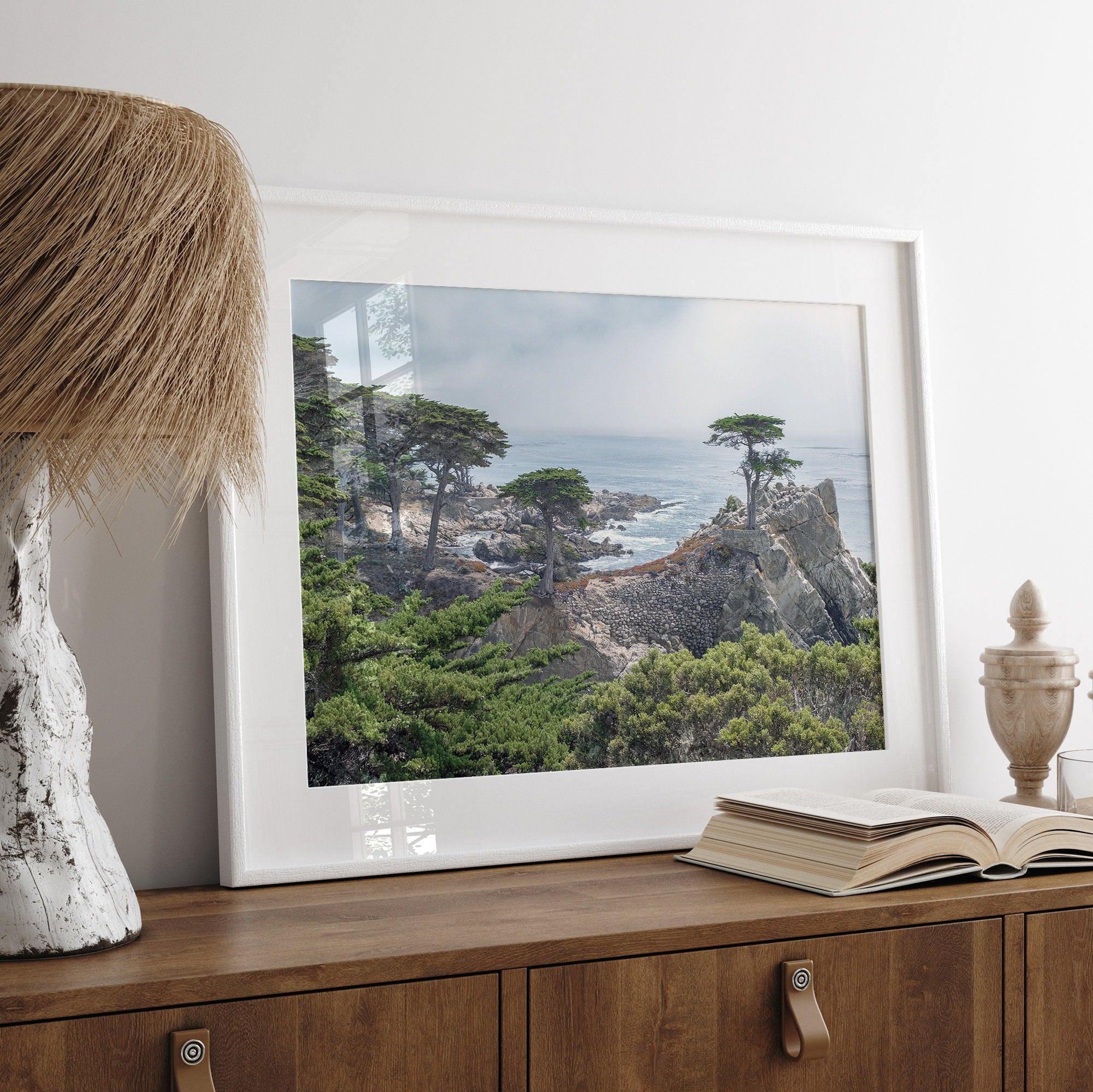 A fine art coastal print showcasing a lone cypress overlooking the ocean in 17 miles drive near Monterey, California. This ocean wall art is available framed or unframed.