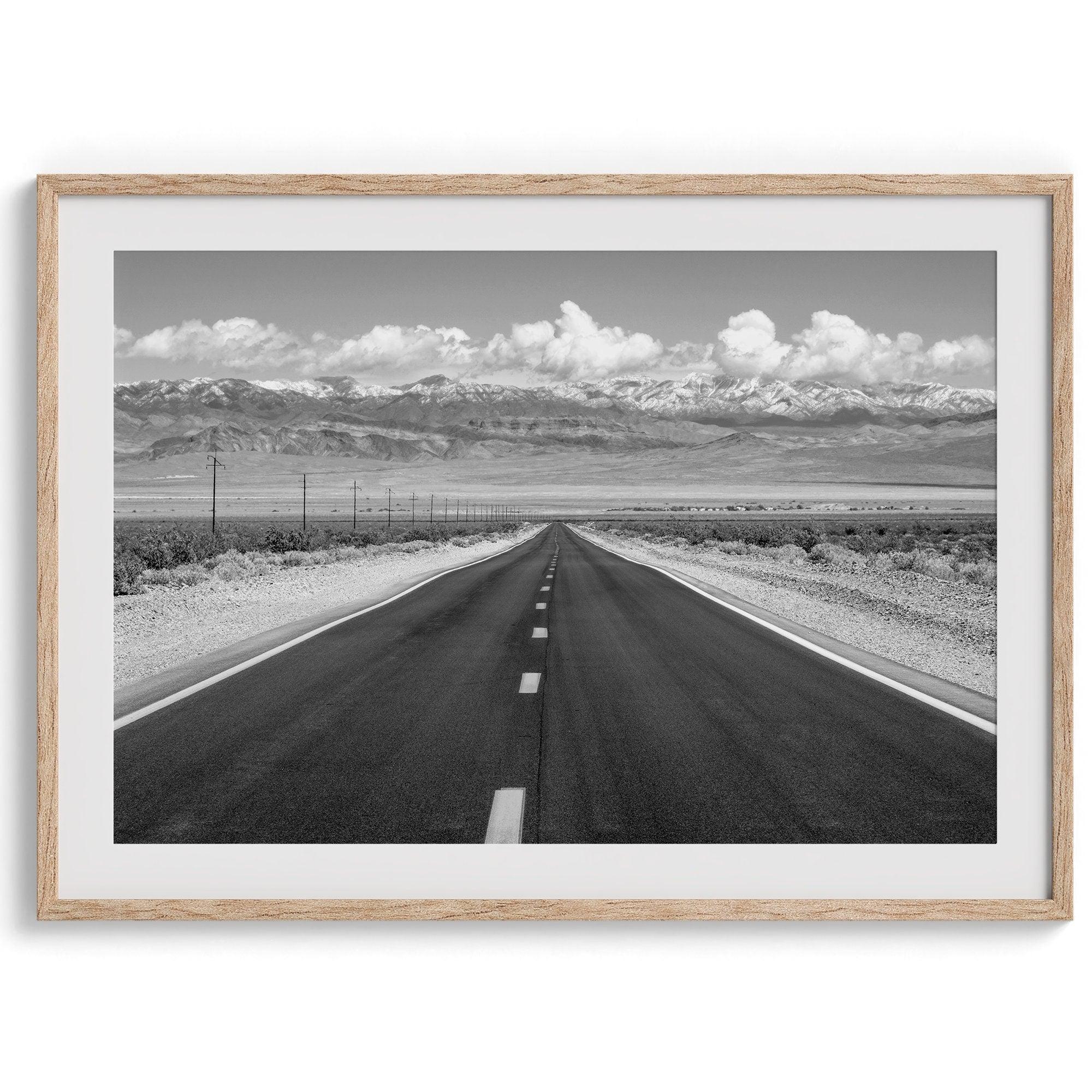 This stunning piece of black and white desert wall art will take your breath away. A beautifully framed picture of a Death Valley National Park road leading towards the snow-covered mountains at the end of the desert.