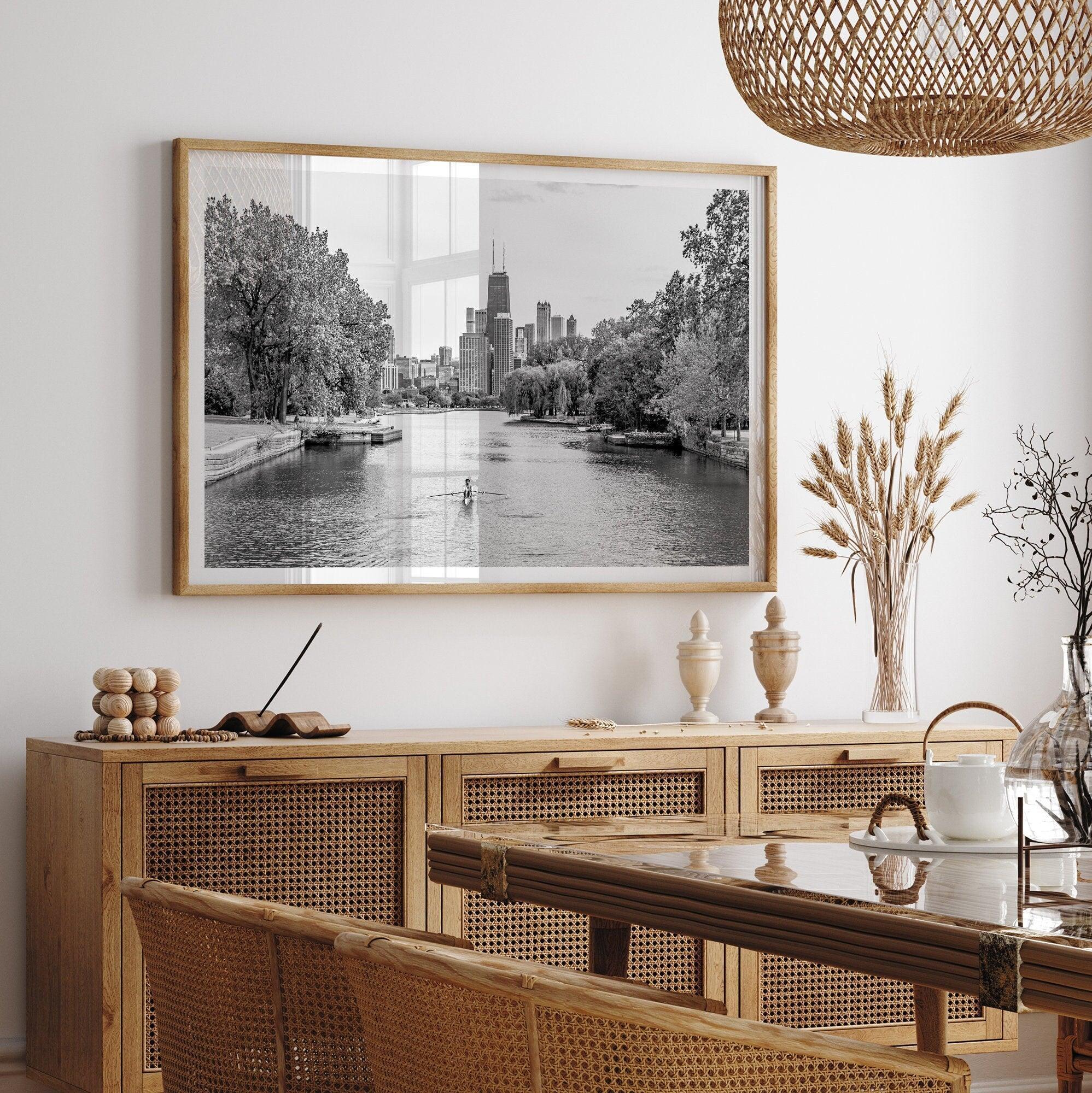 Black and white photo of Lincoln Park, Chicago. A lone rower glides on the park canal with the iconic Willis Tower (formerly Sears Tower) and Chicago skyline in the background.