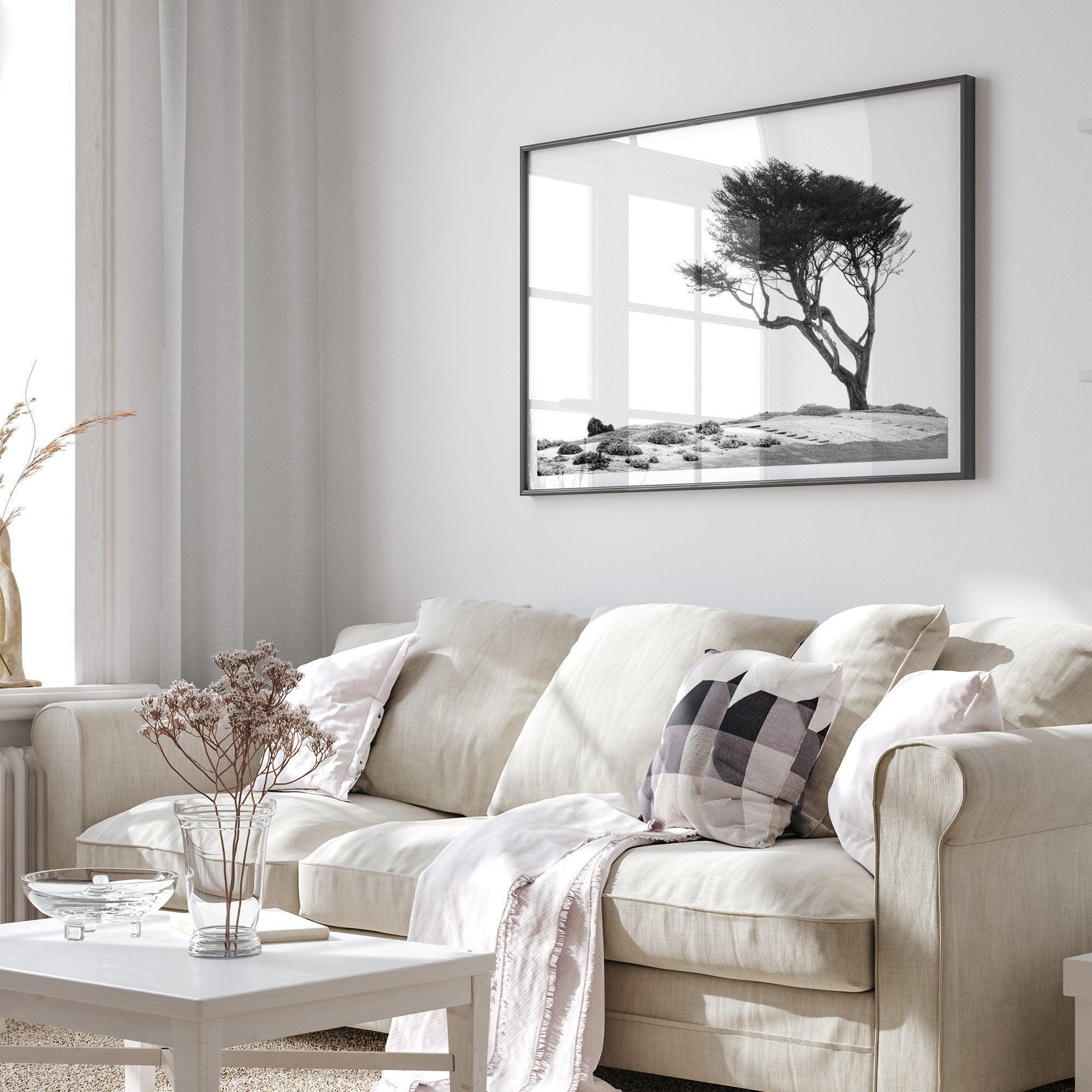 Black and white coastal print: A lone, wind-bent tree stands strong on a dramatic cliff. Weathered rocks and a white sky hint at the power of the unseen ocean